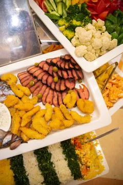 Fish slicing and various dishes on the buffet in the restaurant Stock Photos