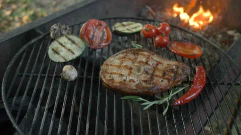 Fish steak with a slice of tomato, zucchini, mushrooms, cherry tomatoes, cloves Stock Footage 93345455