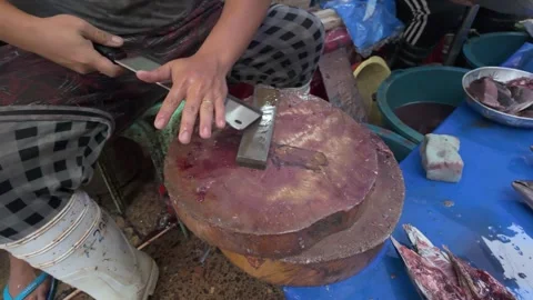 A Fish street vendor sharpening a large cleaver knife ready for filleting Stock-Footage 277965843