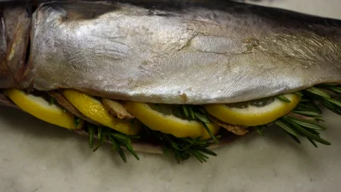 Fish stuffed with lemon, rosemary, ginger, on a salt before baking Stock Footage 233356264