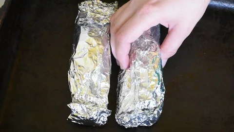 Fish stuffed with vegetables in foil for baking Stock Footage 94936129