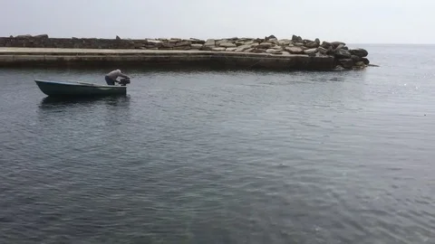 Fisherman adjusting engine of boat Stock-Footage 72819672