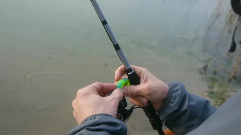 Fisherman attaching a soft plastic lure to the fishing line Stock Footage 322165767