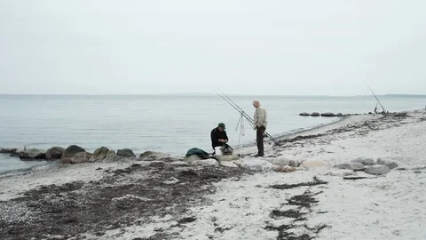 A fisherman on a beach of the baltic sea preparing his fishing gear. Stock Footage 86561388