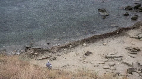 Fisherman on the beach with two rods Stock Footage 60563645