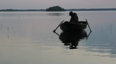 Fisherman in boat rowing Stock Footage 10800447