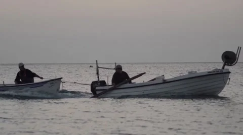 Fisherman is boat towing another boat in the early hours of the morning headi Stock Footage 59588410