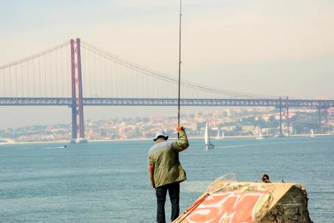 Fisherman with bridge in background Stock Photos