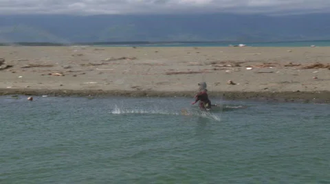 Fisherman cast net out in the stream while camera drives by Video stock 606350