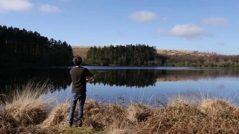 Fisherman casting into a lake Stock Footage 73525198