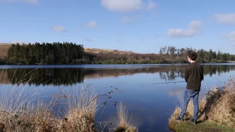 Fisherman casting into a lake 스톡 동영상 73525219