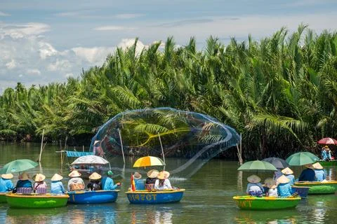 Fisherman casting a large net for tourists in traditional round basket boat.. Foto stock