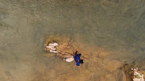 Fisherman casting a traditional net into the shallow river water, aerial to.. Stock Footage 335027817