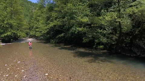 Fisherman casts spinning in shallow river by rapids Stock-Footage 102684700