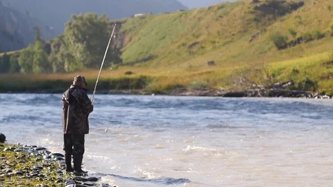 Fisherman catches fish against the backdrop of a mountain landscape. fisherman Видео 106223172