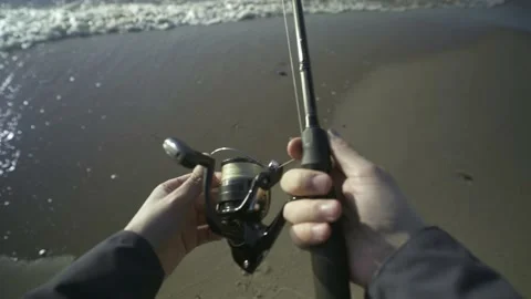 Fisherman catching fish by spinning on the beach. POV shot. Stock Footage 239893418