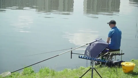 Fisherman caught wild fish on the river in the city. Sport feeder fishing Stock Footage 85137481