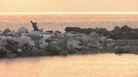 A fisherman on the cliff at sunset Stock Footage 56789844