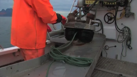 Fisherman coiling rope and using the ships winch system to assist pulling Stock Footage 103530575