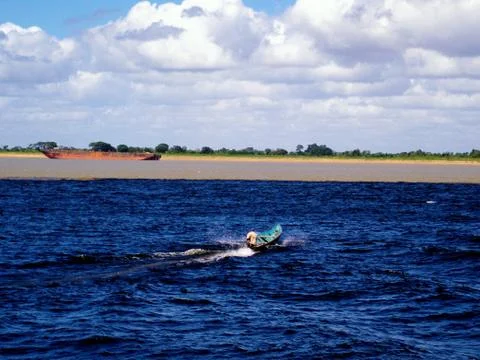 Fisherman crossing confluence between two well-differentiated rivers Stock Photos