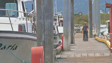 Fisherman dragging fish tote on dock Stock Footage 8565522