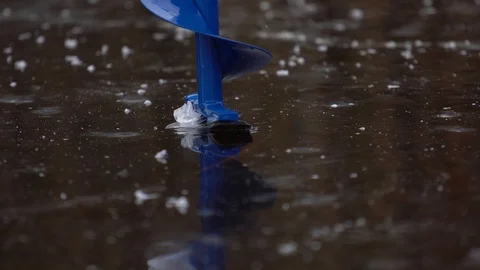 Fisherman drills ice with a drill Video stock 101008249