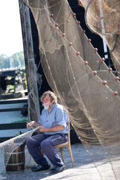 Fisherman fixing his nets Photos