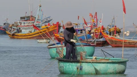 Fisherman fixing nets in boat in round boat,Mui Ne,Vietnam Stock Footage