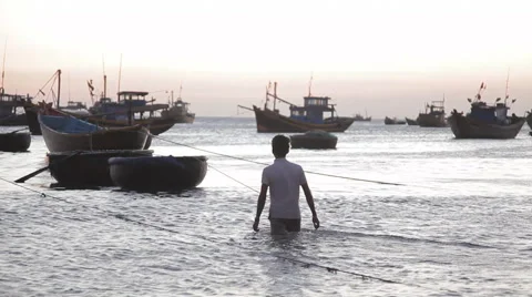 Fisherman going to the round boat in a small harbor (Vietnam). Stock Footage 42884711