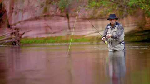 A fisherman in a hat on the river throws the bait towards the viewer Stock-Footage 141215466