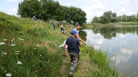 Fisherman helps the young man to throw spinning Stock Footage 112495004