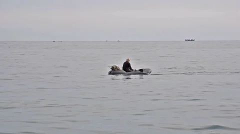 A fisherman in an inflatable boat 動画素材 58900603