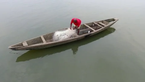 Fisherman inspecting his net in the pirogue Stock Footage 80954488