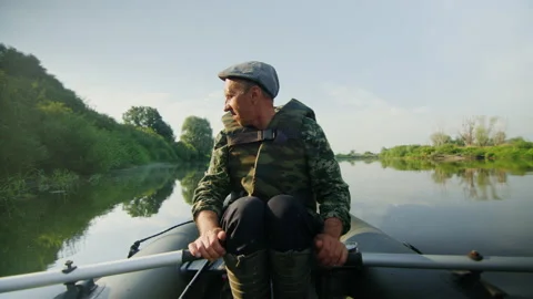 A fisherman in a life jacket rowing a boat in the lake Stock Footage 219776455