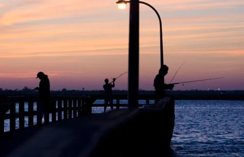 Fisherman On Pier At Twilight Stock Photos