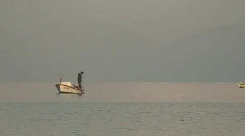 Fisherman pulling in his nets at dawn Video stock 86148