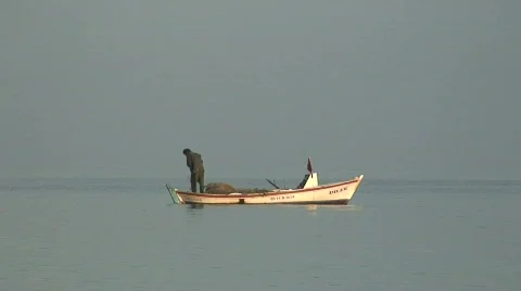 Fisherman pulling in his nets at dawn Stock Footage 86149