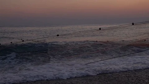 Fisherman pulling net out of water in slow motion Stock Footage 100451320