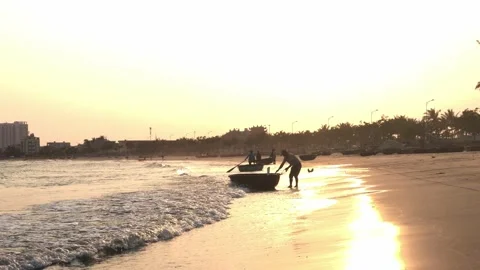 Fisherman pulling a small boat in a beautiful sunset with city skyline Stock Footage 151381225