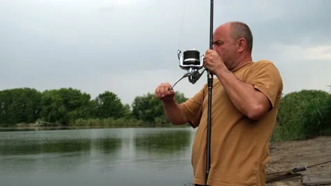 Fisherman pulls the fish out of the river with carp fishing equipment. Angler Stock Footage 162283990