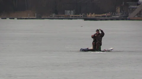 Fisherman Pulls Line catch fish with fishing rod from the ice-hole on a frozen Stock Footage 36533056