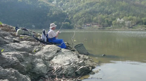 Fisherman pulls out feeder, reeling string on the rod, by Pakito. Stock Footage 62163622