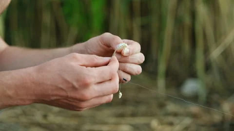 A fisherman puts bait on a hook, semolina Stock Footage 280563944