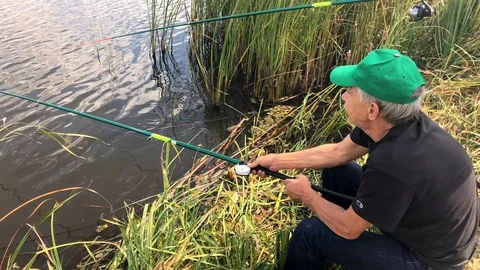 Fisherman puts the corn on the hook and throws the fishing rod into the water Stock-Footage 116648747