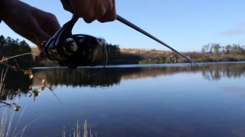 Fisherman reeling in a fish, close up Video stock 73526249