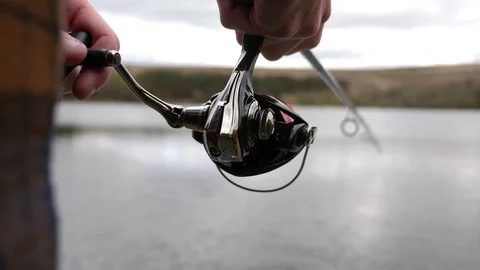 Fisherman reeling in a fish 스톡 동영상 74604524