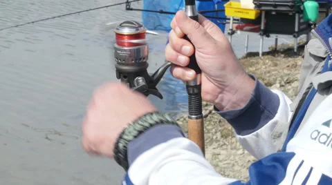 Fisherman reeling string on a stick, holding hands, close up, by Pakito. Video stock 62217466