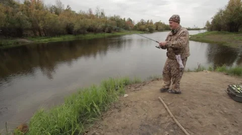 A fisherman on the river caught a small fish on a spinning Stock Footage 55459395