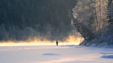 Fisherman on a river at winter sunny day Stock Footage