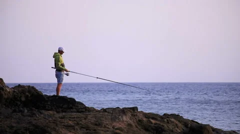 A fisherman on a rock Stock Footage 58123523